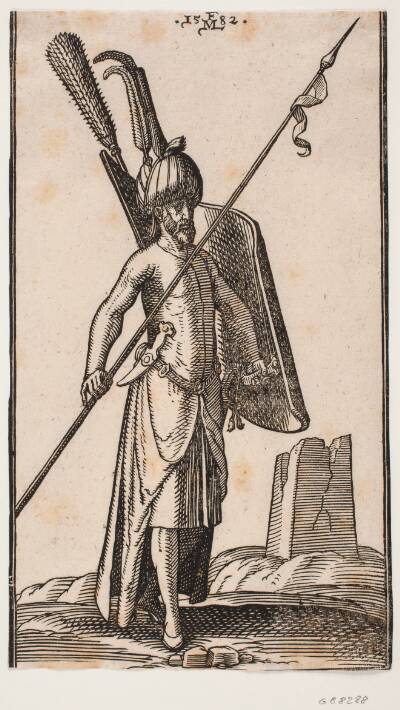 Stående soldat med krumt skjold i v. hånd og i h. hånd et spyd, der holdes skråt; sværd ved hans v. side, en dolk stukket i bæltet ved hans v. side; i baggrunden t.h. ruinen af en obelisk eller et tårn med kvadratisk grundplan