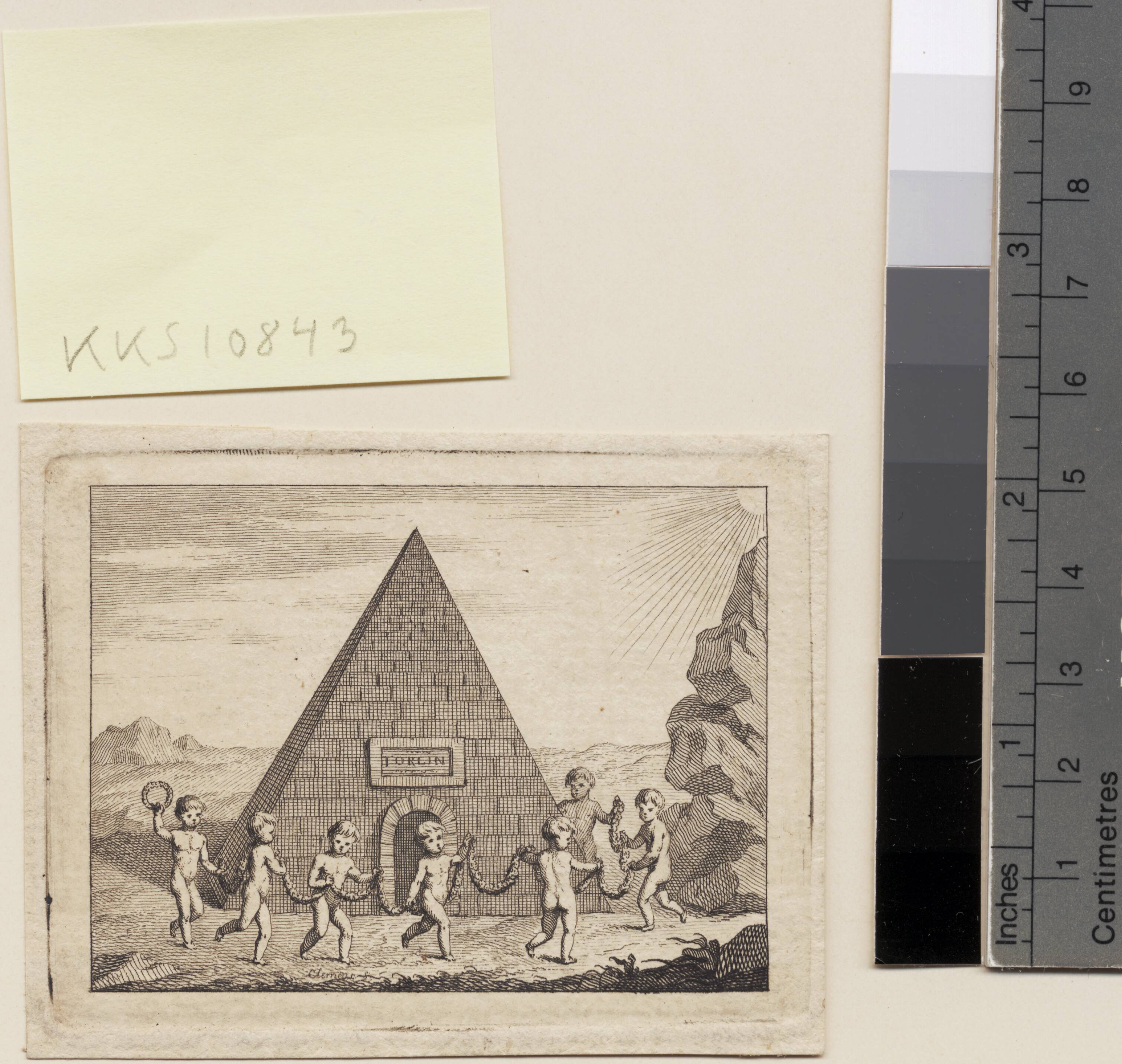 Syv børn danser foran pyramide